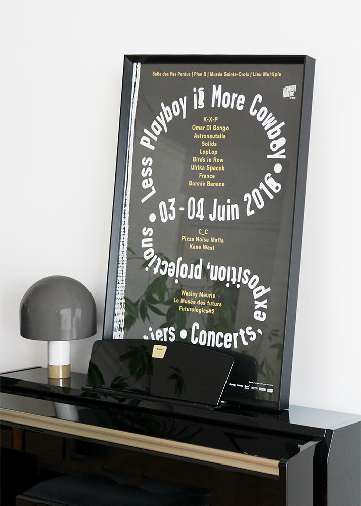 Photographie d'une affiche au format 60x80 cm mise sous cadre noir. Celui-ci repose sur un piano noir.