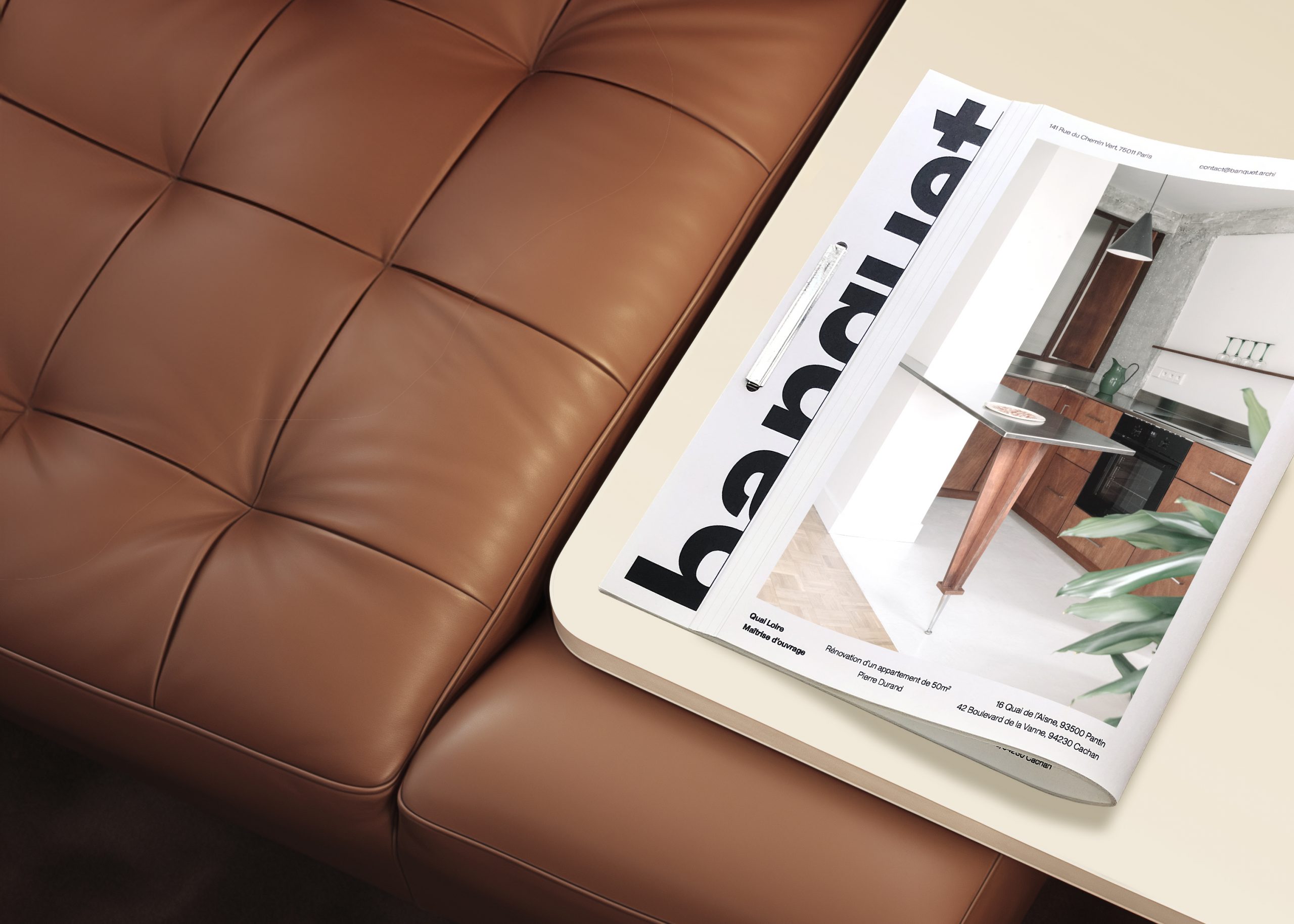 Dossier de présentation banquet plié au format A4, sur une table basse collée à un canapé en cuir marron