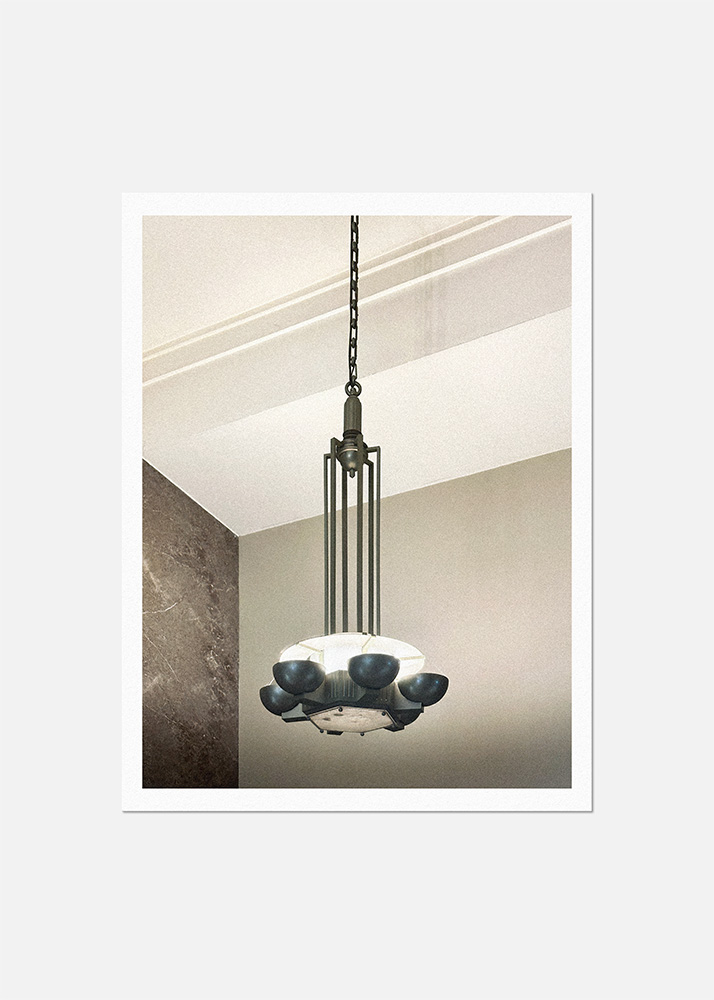 Photographie d'un détail du lieu : un luminaire de style art déco suspendu au plafond.