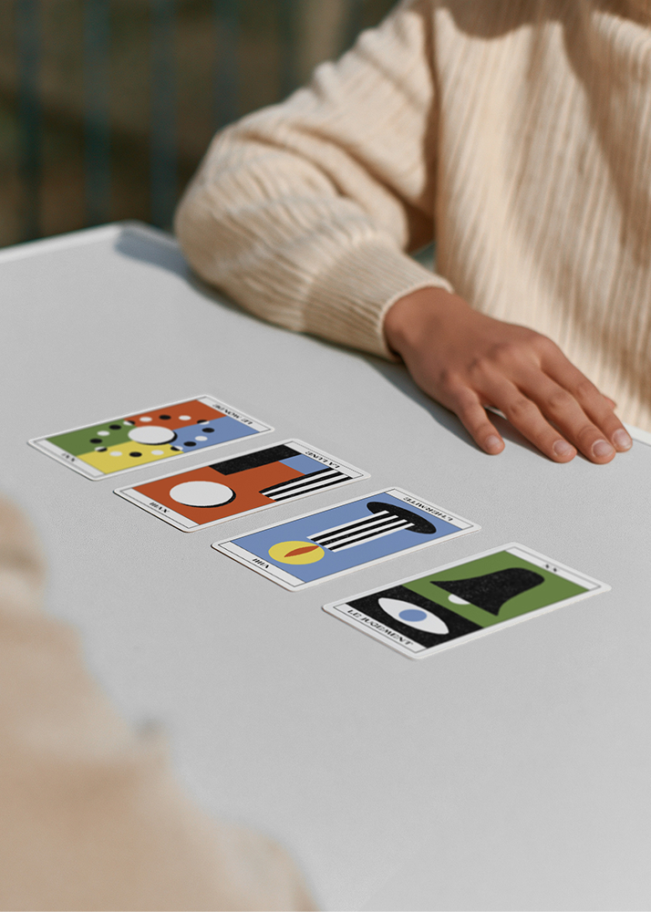 un tirage de 4 cartes majeures est au centre d'une table. on aperçoit le bras et la main de la personne qui vient de tirer les cartes.